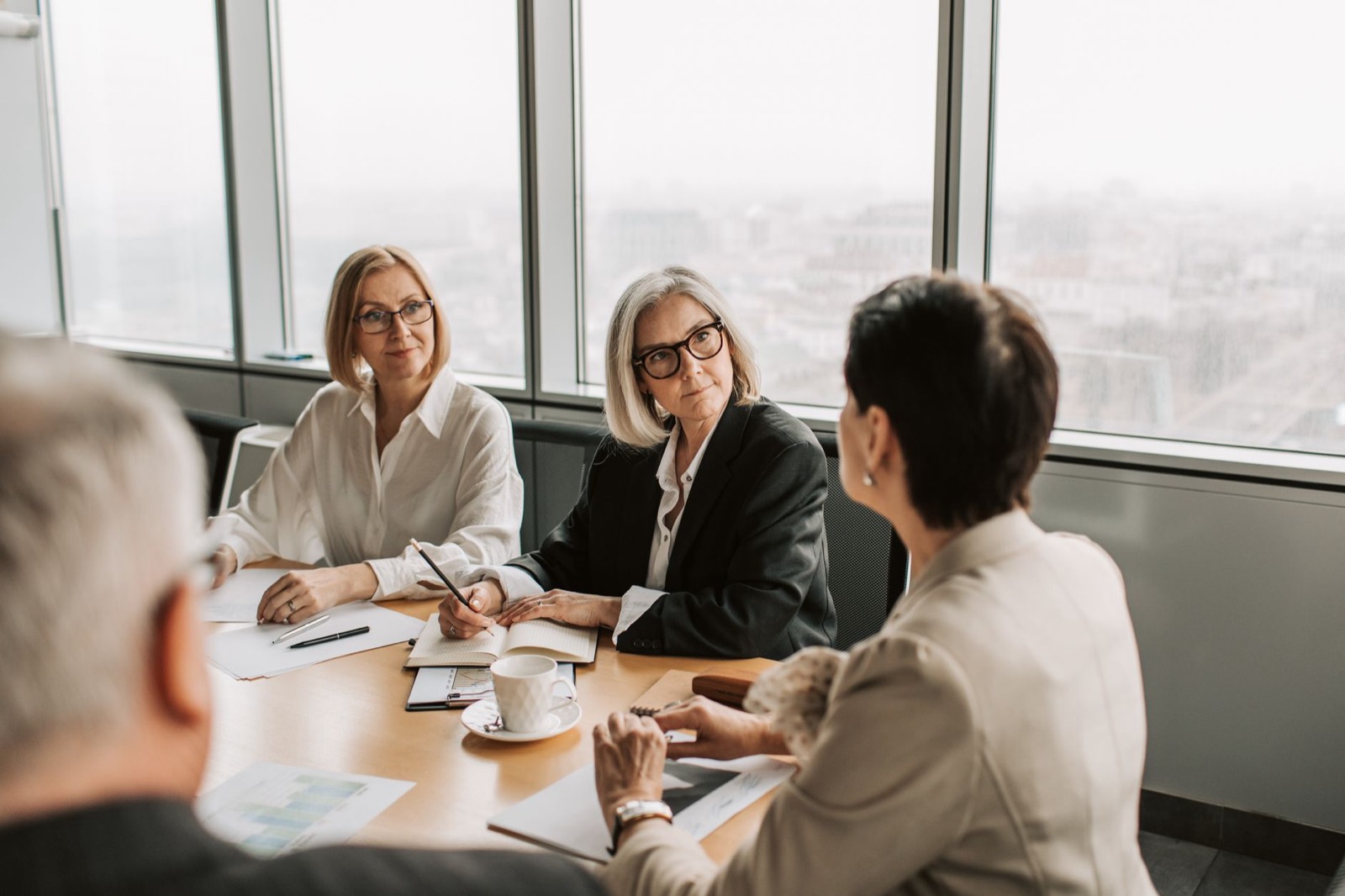 A person speaking up in a team meeting around a table