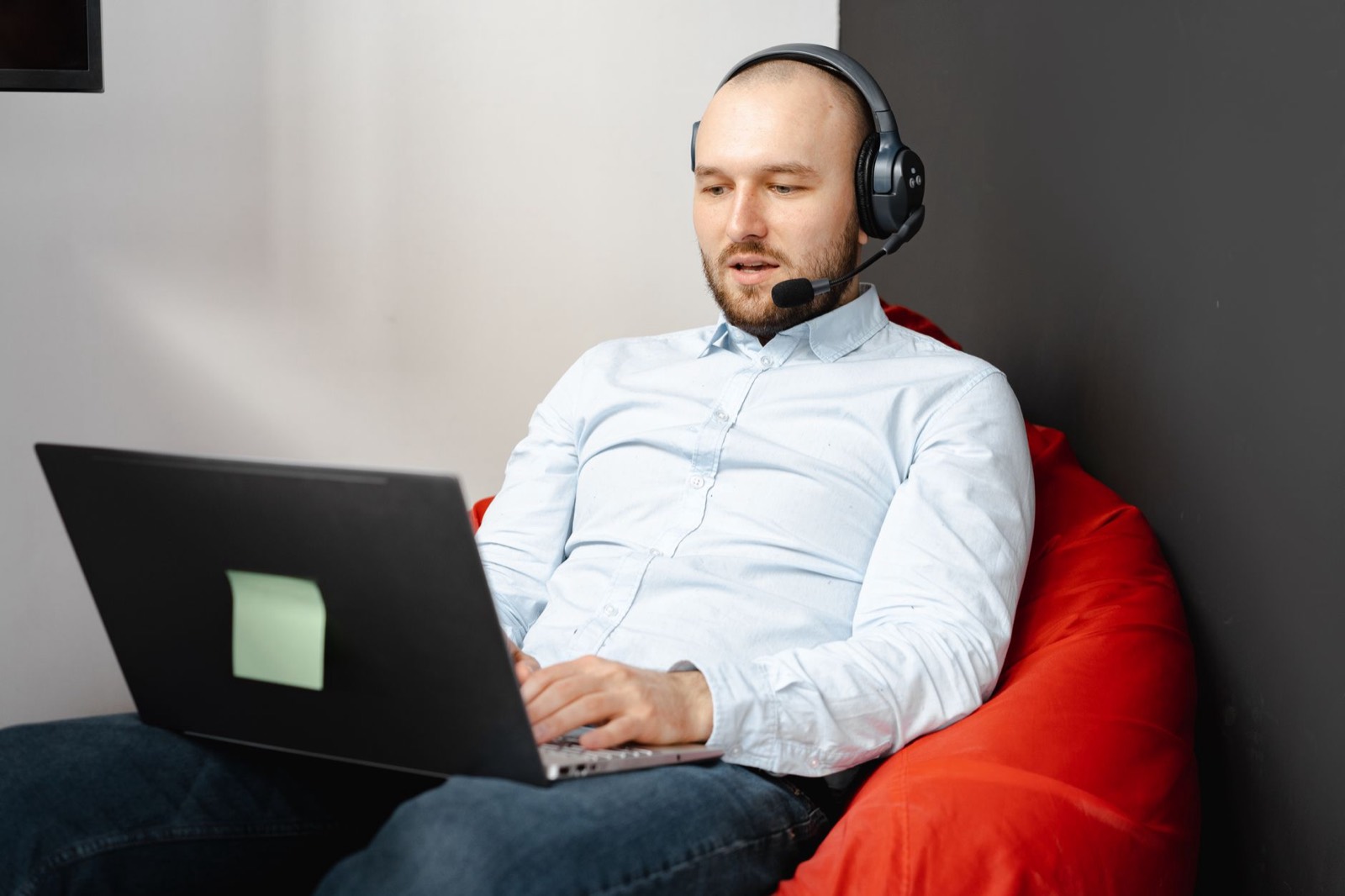 A person on a video call with a headset at a laptop