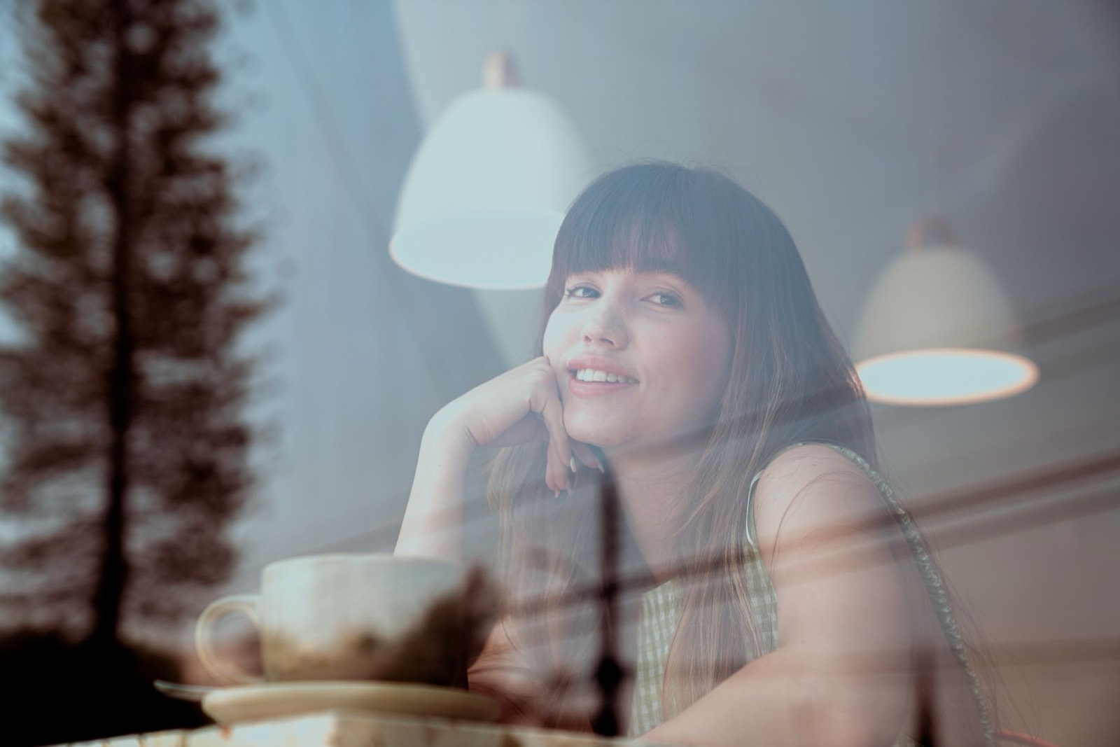A person gathering their thoughts with a coffee by a window