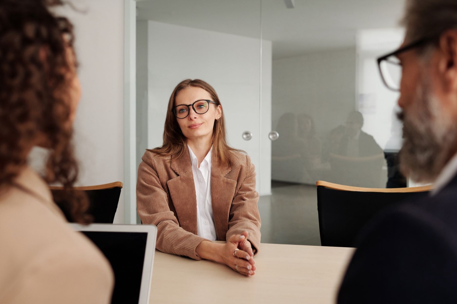 An interview panel talking with a candidate in a bright office